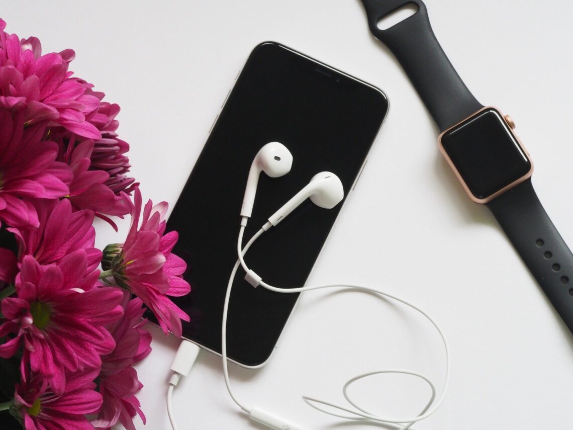 AppleWatch and iPhone on a desk with flowers and headphones. How I used my apple watch in recovery