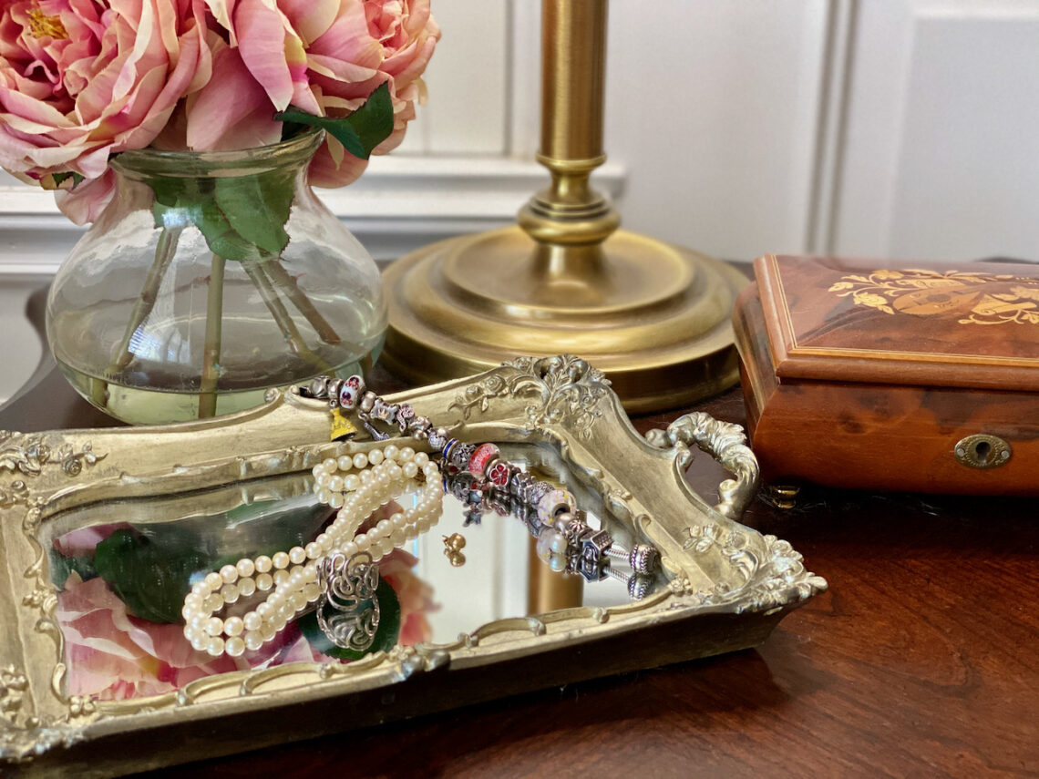Flowers, Silver tray with jewelry and a wooden box on a nightstand. Dressing Beautifully, choosing a signature item