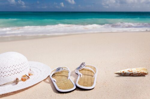 Beach with hat, sandals, and sand. Switching to summer mode in the home