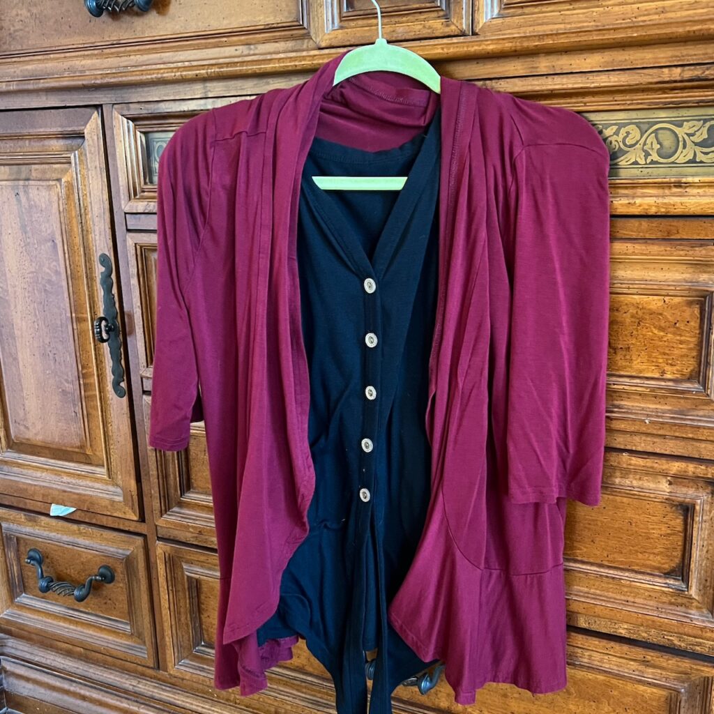 Burgundy cardigan layered over a black button front top