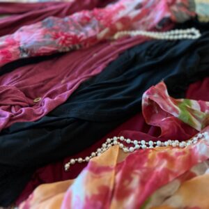 Flat lay of clothing with pearls and floral scarf. create a chic recovery wardrobe