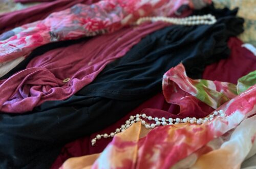 Flat lay of clothing with pearls and floral scarf. create a chic recovery wardrobe