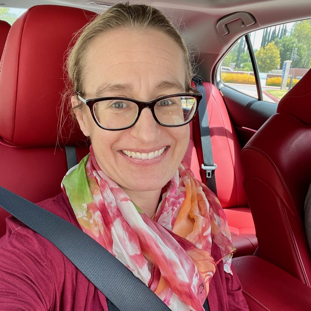 Author in car with pink scarf around her neck