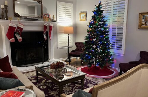 Photo of Author's living room with fireplace, Christmas tree and two couches. Progressive Christmas Decorating