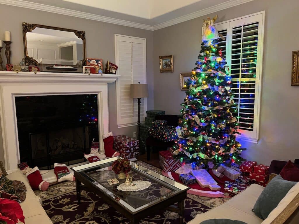 Living room with fireplace, full stockings, and a Christmas tree