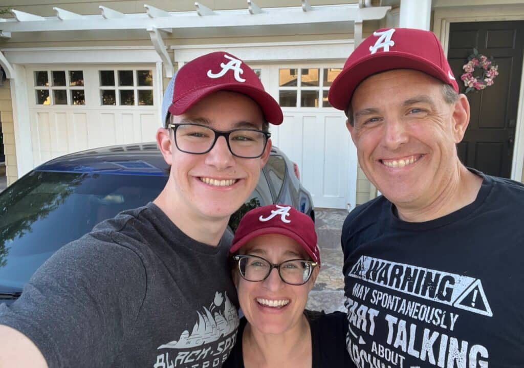 Author with son and husband wearing Alabama hats