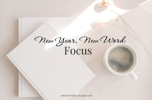 Notebook and coffee on desk. Text says New Year New Word: Focus