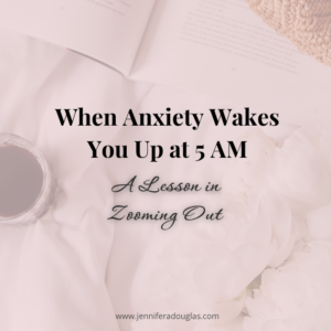 Background image of a bed with a cup of coffee, journal and flowers. Text reads When Anxiety Wakes you up at 5AM: A Lesson in Zooming out