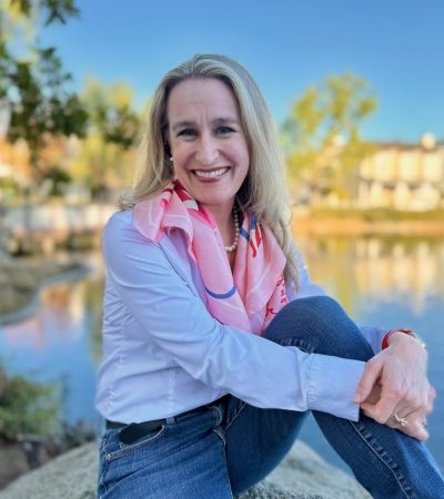 Jennifer Douglas, DCIS survivor and breast cancer patient advocate, smiling outdoors by a lake